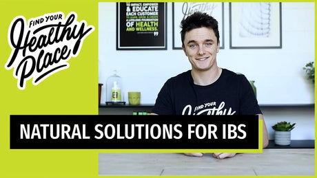 A smiling man in a "Find Your Healthy Place" t-shirt sits at a table. Bold text on a lime green border reads "Natural Solutions for IBS," promoting natural health remedies.