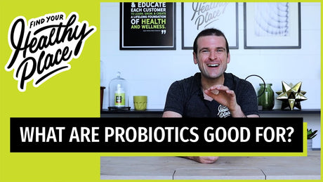 A video thumbnail from "The Healthy Place" featuring a smiling man at a table with bold text reading "WHAT ARE PROBIOTICS GOOD FOR?" and the brand’s logo on a lime green background.
