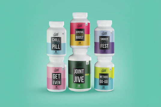 A set of five white supplement bottles from Lovely Nutrition, each with colorful labels and playful names: "Chill Pill," "Adrenal Boost," "Snooze Fest," "Get Even," "Joint Jive," and "Metabo Go-Go," arranged in a pyramid formation against a teal background.