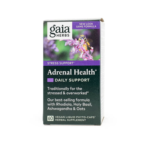 Front of a box of Gaia Herbs Adrenal Health® Daily Support, a vegan herbal supplement for stress support. The label highlights its formula for the stressed and overworked, featuring Rhodiola, Holy Basil, Ashwagandha, and Oats, with 60 liquid phyto-caps. Purple floral imagery and branding details are visible.