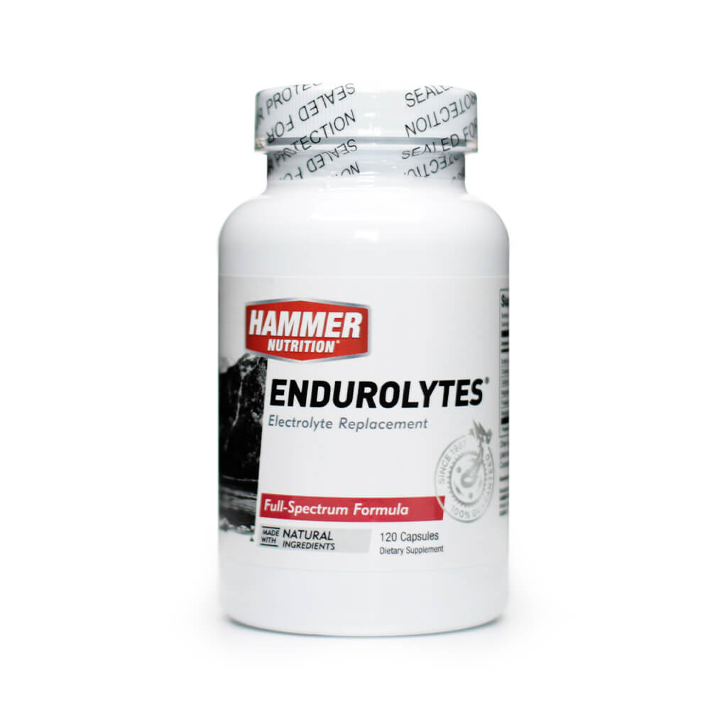 A white bottle of Hammer Nutrition Endurolytes, labeled as an electrolyte replacement supplement with a full-spectrum formula. The front of the bottle states it contains 120 capsules, is made with natural ingredients, and features a black mountain image with red and black text accents.