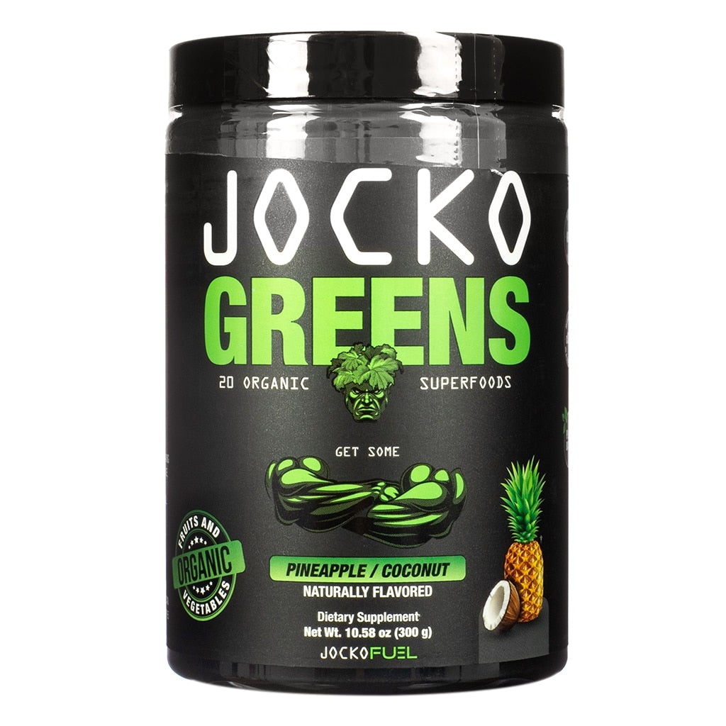 A sleek black tub of Jocko Greens powdered supplement featuring bold green and white text with a muscular leafy mascot, labeled “20 Organic Superfoods.” The pineapple/coconut flavor is highlighted at the bottom alongside fruit illustrations, and the container notes it’s naturally flavored and weighs 10.58 oz (300g).