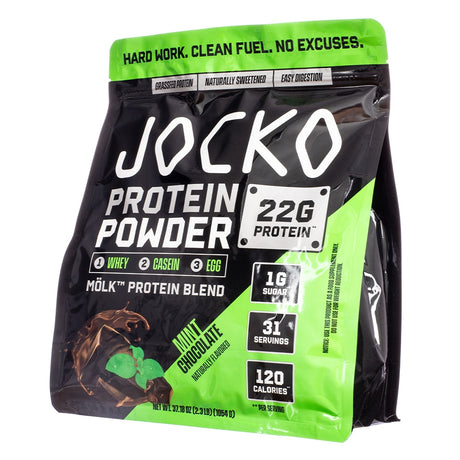 A striking black and green Jocko Mölk protein powder bag featuring mint leaves and chocolate pieces to represent the mint chocolate flavor. The label promotes 22g protein, 1g sugar, 120 calories per serving, and a grass-fed, naturally sweetened, and easy-to-digest blend.