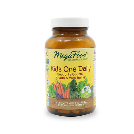 A brown glass bottle of MegaFood Kids One Daily multivitamin and mineral dietary supplement, containing 60 tablets. The label is yellow with green accents and features images of carrots, kale, and lavender, promoting optimal health and well-being for children.