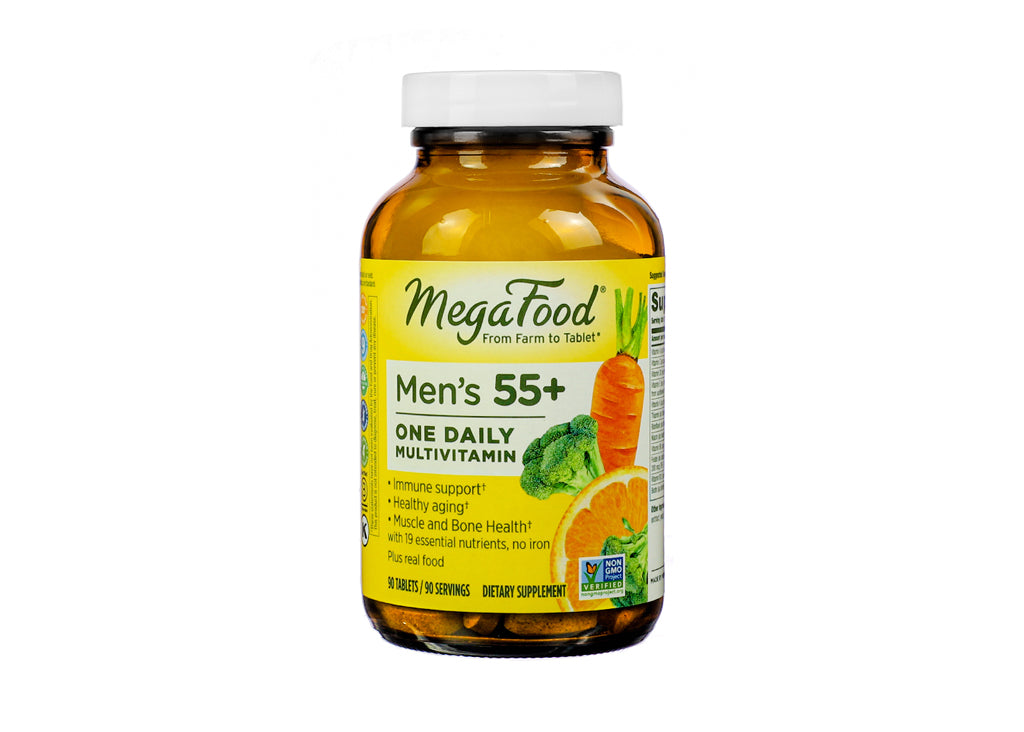 Amber bottle of MegaFood Men’s 55+ One Daily Multivitamin with 90 tablets. The label highlights support for immune health, healthy aging, and muscle and bone strength, featuring 19 essential nutrients without iron. The design includes illustrations of carrots, broccoli, and orange slices.