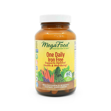 MegaFood One Daily Iron Free Multivitamin bottle with a white cap and yellow label, featuring the text “Supports Optimal Health & Well-Being” and a colorful illustration of carrots, leafy greens, and lavender. The bottle contains 60 tablets and highlights that it is a multivitamin and mineral dietary supplement.