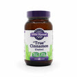 Amber bottle with a purple lid labeled “Oregon’s Wild Harvest True Cinnamon (Ceylon).” The label notes it's made with organic cinnamon, verified non-GMO, and contains 60 gelatin capsules. Features green leaf graphics and a white and purple color scheme.