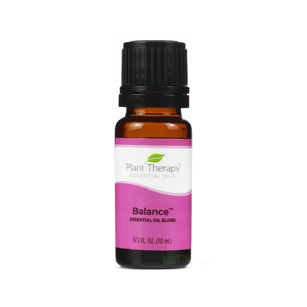 A 10 ml amber glass bottle of Plant Therapy’s “Balance” essential oil blend with a pink and white label and a black screw cap. The label includes the brand’s green leaf logo and product details in black text.