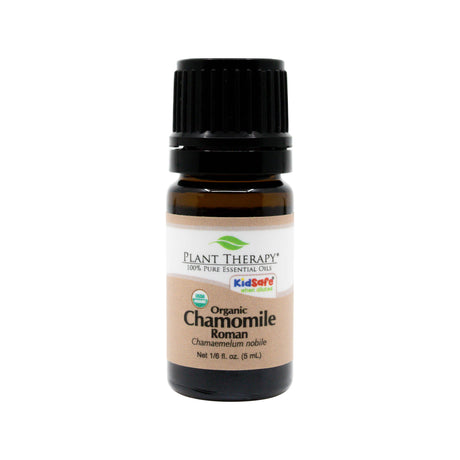 A 5ml / 1/6 fl oz. amber glass bottle of Plant Therapy Organic Chamomile Roman Essential Oil with a black cap. The beige and white label features the brand name, "Organic Chamomile Roman," and "Chamaemelum nobile." It includes "KidSafe when diluted" and USDA Organic certification.