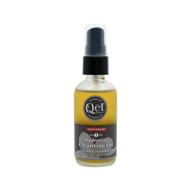 A 2 oz frosted glass pump bottle of Qēt Botanicals Hydrating Cleansing Oil with Lavender, labeled as Core Step 1 in a facial skincare routine. The golden-toned oil is housed in a sleek bottle with a black and gray label, designed to gently cleanse and moisturize the skin.