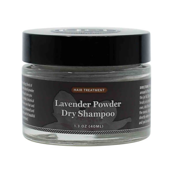 A small 1.3 oz glass jar of Lavender Powder Dry Shampoo labeled as a hair treatment, featuring a black screw-on lid and dark label with light gray text. The packaging suggests a botanical formula designed to refresh hair without water.