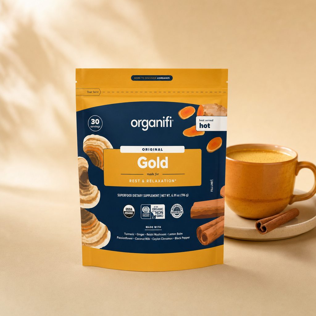 Organifi Gold pouch beside a prepared golden drink in a glass
