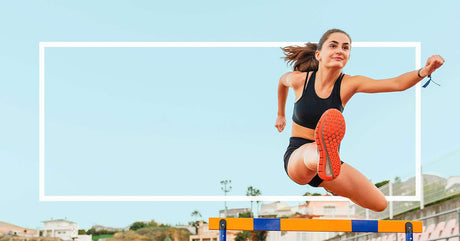 A female athlete in black sportswear jumps over a hurdle on a track, framed by a white rectangular border.