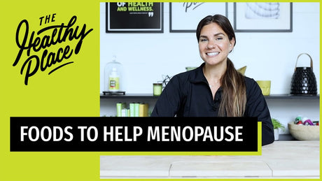 A video thumbnail from "The Healthy Place" featuring a smiling woman at a table, with bold text reading "FOODS TO HELP MENOPAUSE" and the brand’s logo on a lime green background.