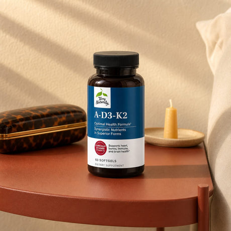 Terry Naturally A-D3-K2 bottle and softgels arranged on a bright wellness counter