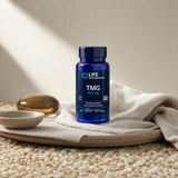 Life Extension TMG 500 mg bottle beside water glass in a morning supplement setup