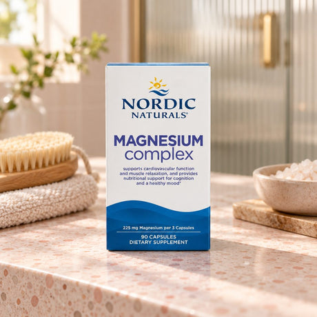 Nordic Naturals Magnesium Complex 90 capsules box on a terrazzo bathroom counter with a bath brush and bath salts