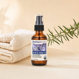 Motherlove Birth & Baby Oil lifestyle scene with baby care items on a soft nursery surface
