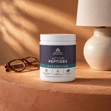 Ancient Nutrition Active Peptides Metabolism Powder Chocolate displayed in a countertop lifestyle setting