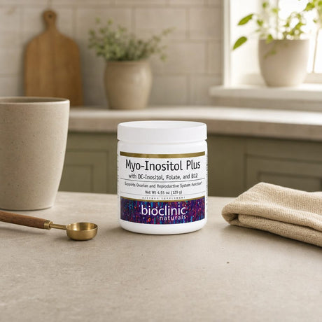 BioClinic Naturals Myo-Inositol Plus bottle beside a glass of water on a countertop