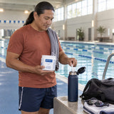 Pure Encapsulations Ascorbic Acid Powder held by a man at an indoor pool, adding a scoop to a water bottle
