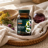 Gaia Herbs Berberine & Milk Thistle bottle posed outdoors against green mountain scenery