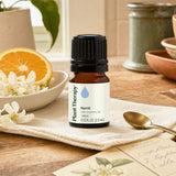 Neroli essential oil bottle with orange blossom flowers and citrus slices