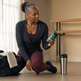 Ancient Nutrition Mixed Berry plant powder scoop and berry smoothie on counter