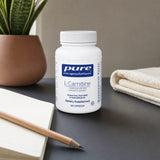 Pure Encapsulations L-Carnitine 120 capsules bottle beside fitness gear