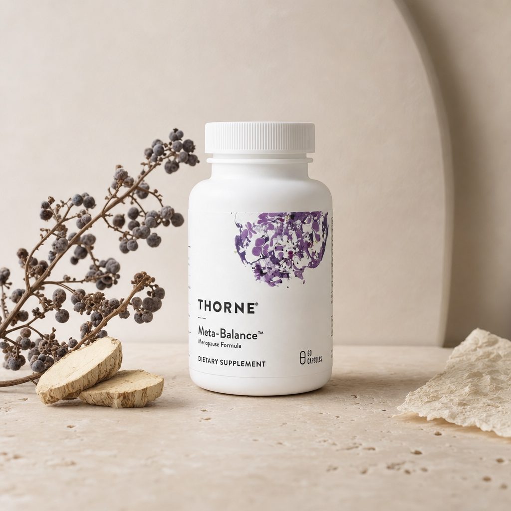 Woman in her 40s holding Thorne Research Meta-Balance Capsules during a morning wellness routine