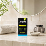 Redmond Re-Lyte Lemon Lime stick packs beside prepared electrolyte drink