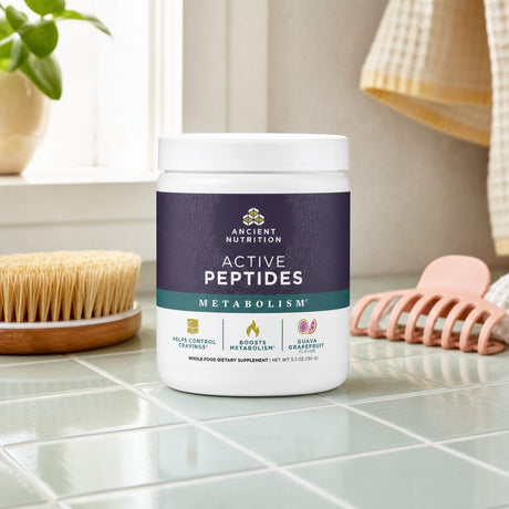 Ancient Nutrition Active Peptides Metabolism Powder Guava Grapefruit beside a prepared tropical drink