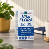 Vital Planet Vital Flora Ultra Daily Probiotic box on a table beside a plant, notebook and mug