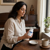 Woman holding Pure Encapsulations Choline bottle with daily supplement organizer