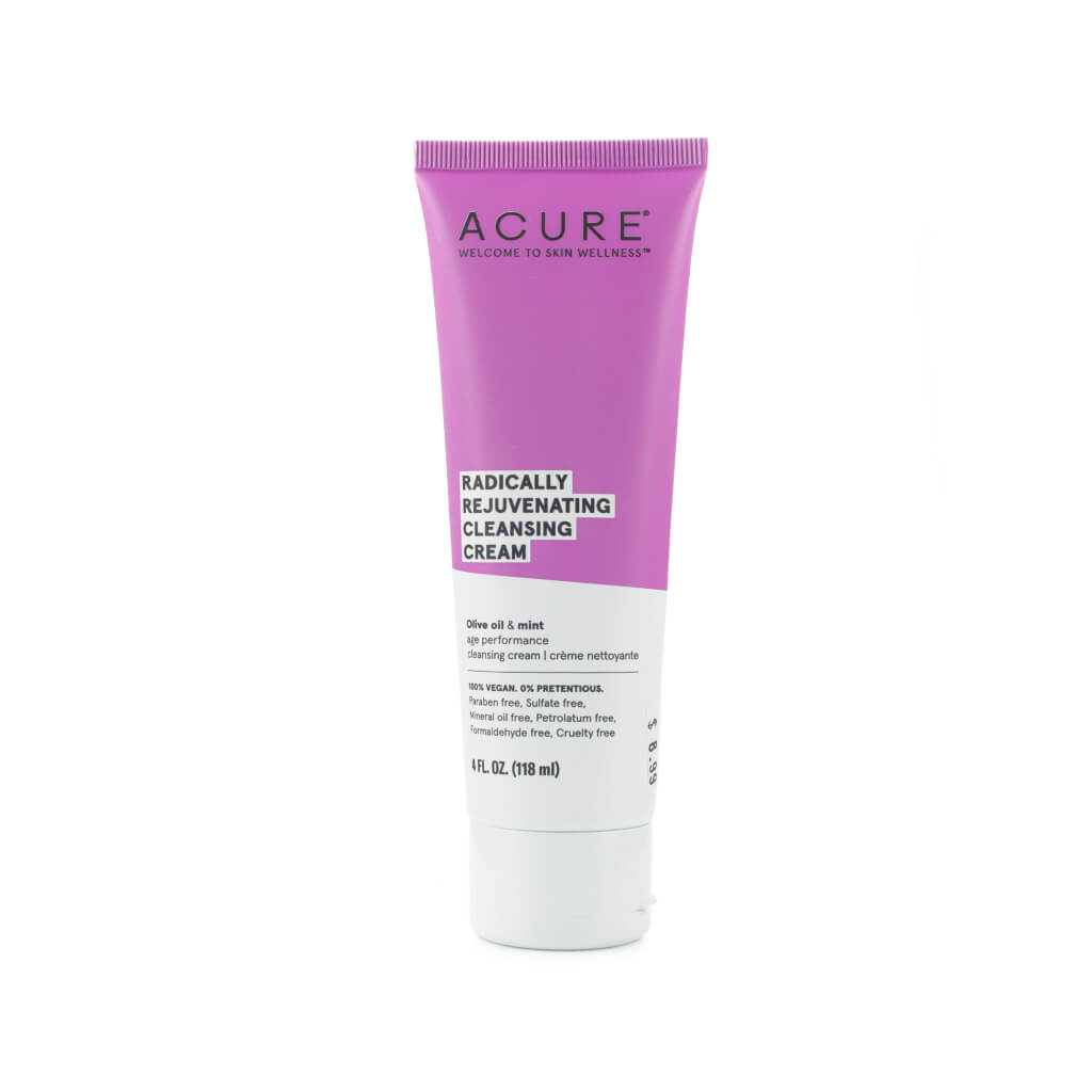 A 4 fl oz tube of Acure Radically Rejuvenating Cleansing Cream with a purple and white design, featuring olive oil and mint as key ingredients. The label highlights that it’s 100% vegan and free of parabens, sulfates, mineral oil, and other common irritants.
