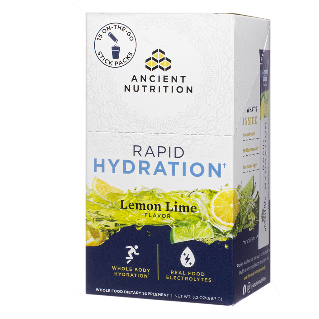 The front label of Ancient Nutrition Rapid Hydration Lemon Lime 3.2 oz Stick Packs highlights flavor and benefits like whole body hydration and real food electrolytes, with imagery of splashing lemons and limes and a callout for 15 on-the-go stick packs.
