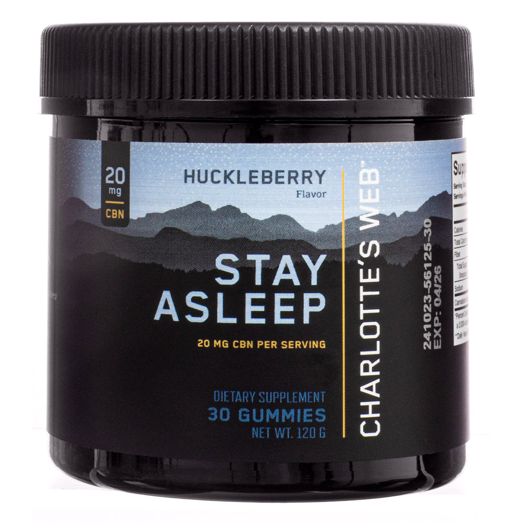 The front view of Charlotte's Web Stay Asleep Gummies, 30-count, Huckleberry flavor, in a black plastic jar with a black screw-on lid. The label features a mountain silhouette against a starry sky, with bold white and gold text stating "Stay Asleep" and "20 mg CBN per serving." The dietary supplement is designed for sleep support.