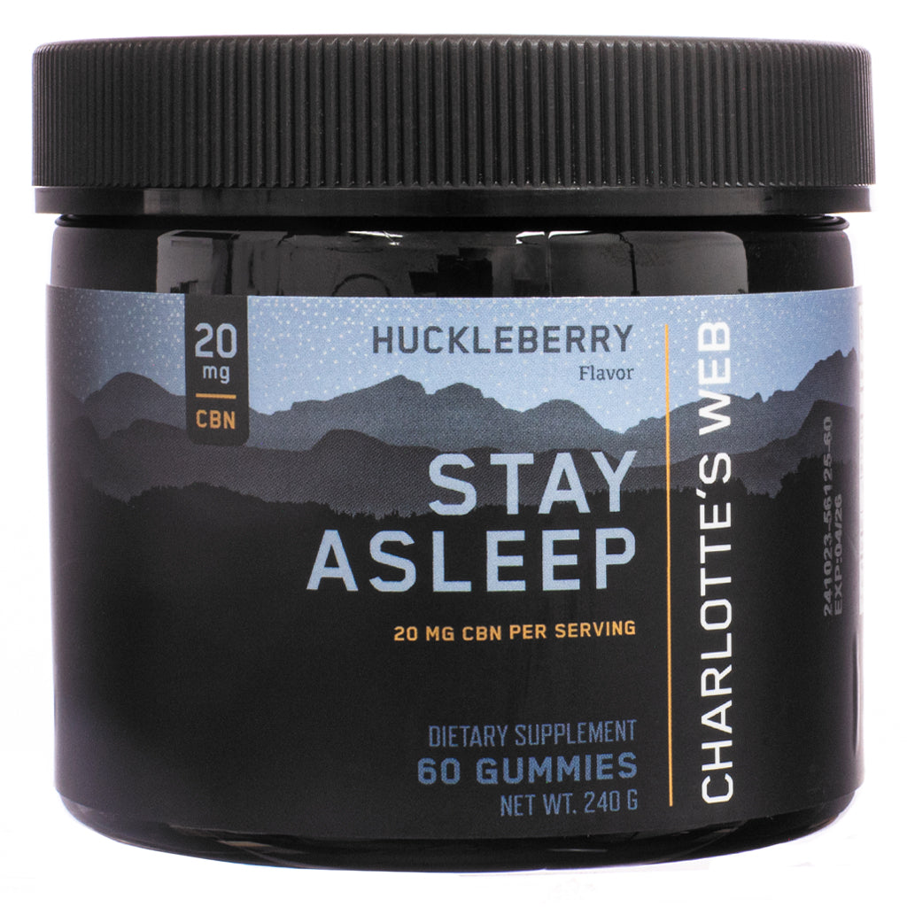 The front view of Charlotte's Web Stay Asleep Gummies, 60-count, Huckleberry flavor, in a black plastic jar with a black screw-on lid. The label features a mountain silhouette against a starry sky, with bold white and gold text stating "Stay Asleep" and "20 mg CBN per serving." The dietary supplement is designed to support sleep quality and duration.