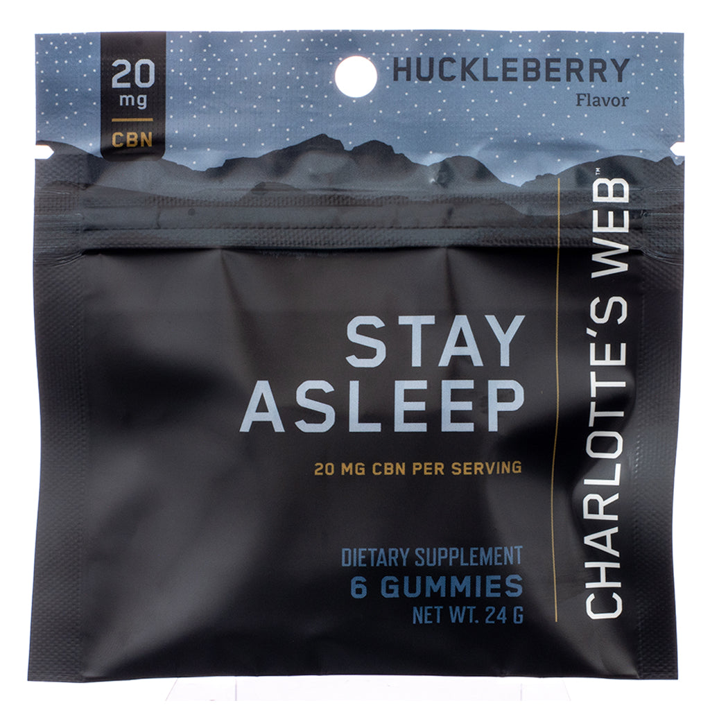 A black resealable pouch of Charlotte's Web Stay Asleep Gummies, featuring the front label with product branding. The packaging highlights 20 mg CBN per serving, huckleberry flavor, and states that it is a dietary supplement containing 6 gummies with a net weight of 24g.