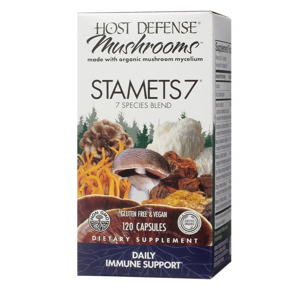 A white rectangular box labeled "Host Defense Mushrooms Stamets 7," showcasing a colorful blend of seven mushroom species, including cordyceps and lion’s mane, against a forest backdrop. This daily immune support supplement is gluten-free, vegan, and contains 120 capsules made with organic mushroom mycelium.