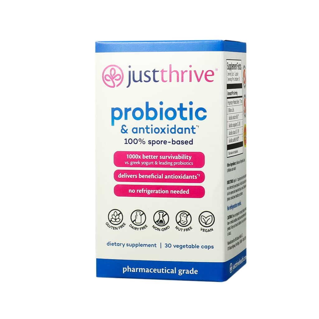 A rectangular box of Just Thrive Probiotic & Antioxidant featuring a clean, clinical design in white and blue with pink accents. It contains 30 vegetable capsules and highlights benefits like 1000x better survivability than yogurt, antioxidant delivery, no refrigeration needed, and is labeled gluten-free, dairy-free, non-GMO, nut-free, and vegan.