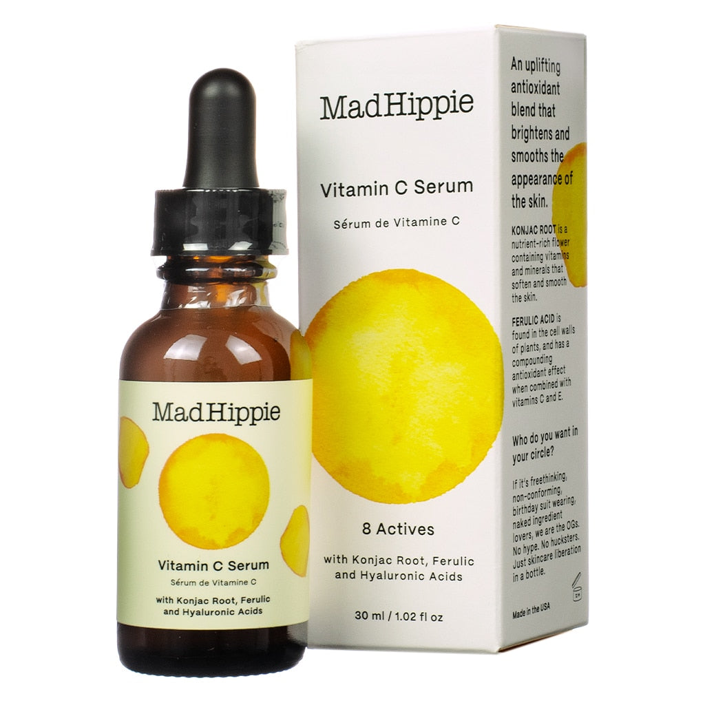 A 1.02 fl oz / 30 ml bottle of Mad Hippie Vitamin C Serum with a dropper, placed beside its box. The packaging highlights 8 actives, such as konjac root, ferulic acid, and hyaluronic acids, offering brightening and smoothing benefits for the skin.