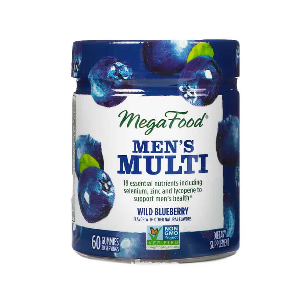MegaFood Men’s 55+ One Daily Multivitamin in a clear amber glass bottle with a white cap, featuring 90 tablets. Label highlights include “Immune support,” “Healthy aging,” and “Muscle and Bone Health,” with 19 essential nutrients and no iron. Illustrated with bright images of carrots, broccoli, and an orange slice.