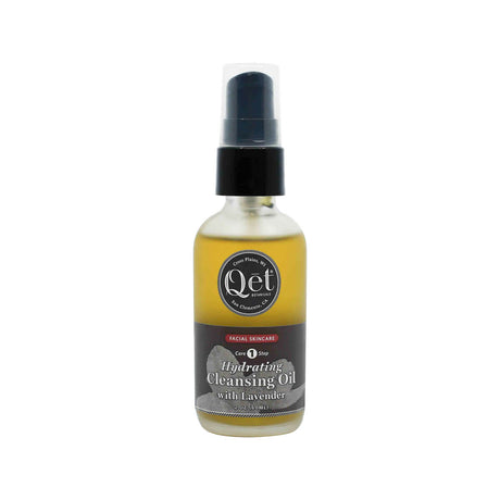 A 2 oz frosted glass pump bottle of Qēt Botanicals Hydrating Cleansing Oil with Lavender, labeled as Core Step 1 in a facial skincare routine. The golden-toned oil is housed in a sleek bottle with a black and gray label, designed to gently cleanse and moisturize the skin.