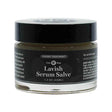 A 1.3 oz glass jar of Qēt Botanicals Lavish Serum Salve labeled as a luxury treatment and Care Step E. The dark label notes it’s suitable for all skin types and designed to deeply nourish areas like the face, hands, lips, and chest.