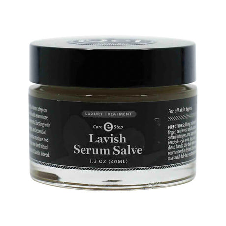 A 1.3 oz glass jar of Qēt Botanicals Lavish Serum Salve labeled as a luxury treatment and Care Step E. The dark label notes it’s suitable for all skin types and designed to deeply nourish areas like the face, hands, lips, and chest.