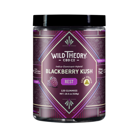 A tall jar of Wild Theory CBD Co. REST Blackberry Kush gummies with a rich purple label featuring an ornate geometric pattern. The Wild Theory logo is centered at the top, with "Indica-Dominant Hybrid" and "Blackberry Kush" written below. The label emphasizes "REST" in a purple box, "Extra Strength" in a yellow badge, and states "8mg Custom Terpene Blend with Live Resin." The dosage details read "10mg THC (2mg CBD, 7mg CBN)" per serving. The jar contains "120 Gummies" with a net weight of "18.6 oz (528g)." 