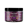 A jar of Wild Theory CBD Co. REST Blackberry Kush gummies with a purple geometric label. It features a bold white brand logo at the top, with "Indica-Dominant Hybrid" below it. The flavor "Blackberry Kush" is prominently displayed in white text, along with the word "REST" in a purple box. Additional details include "Extra Strength" in a yellow badge, "8mg Custom Terpene Blend with Live Resin," and dosage information: "10mg THC (2mg CBD, 7mg CBN)." The container holds "30 Gummies" with a net weight of "4.65 