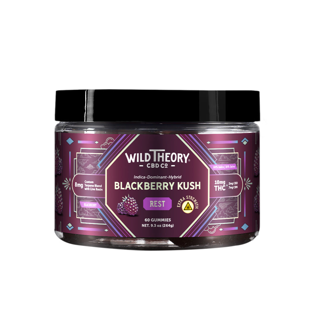 A jar of Wild Theory CBD Co. REST Blackberry Kush gummies, featuring a purple geometric-patterned label. The brand logo is displayed at the top, followed by "Indica-Dominant Hybrid" and the product name "Blackberry Kush." The label highlights "REST" in a purple box, "Extra Strength" in a yellow badge, and "8mg Custom Terpene Blend with Live Resin." It states "10mg THC (2mg CBD, 7mg CBN)" per serving. The container holds "60 Gummies" with a net weight of "9.3 oz (264g)." The bottom left corner includes icons