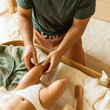 Motherlove Birth & Baby Oil shown with baby care callouts and organic product benefits